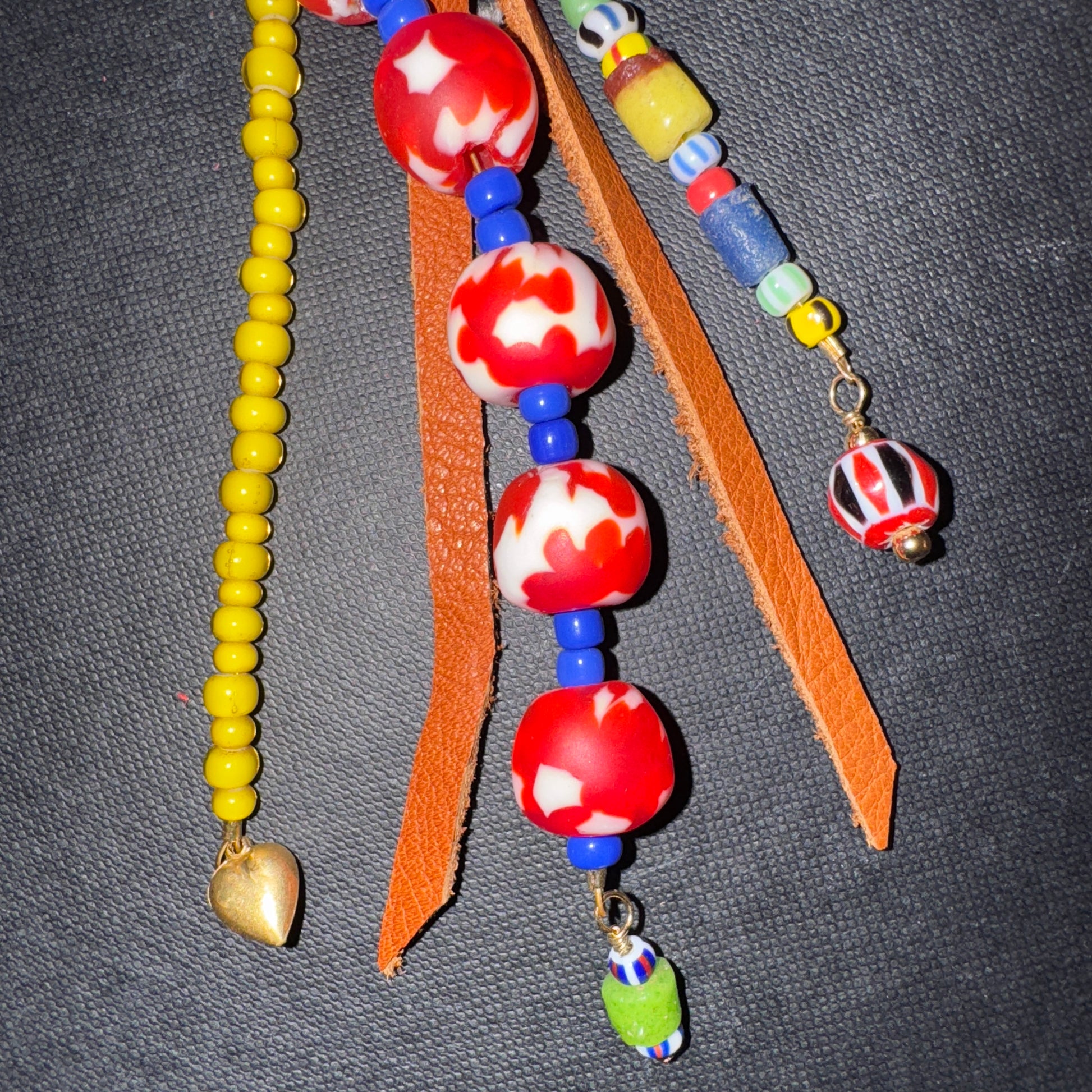Colorful beaded necklace with red and white beads on a gray background
